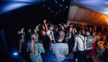 DJ and Sax supplied by Start to Finish Music perform to wedding guests in a marquee.