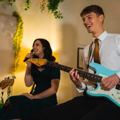 wedding band for hire sits with instruments ready to perform for guests. Wedding band performs for all events, such as weddings, corporate parties and christmas parties.