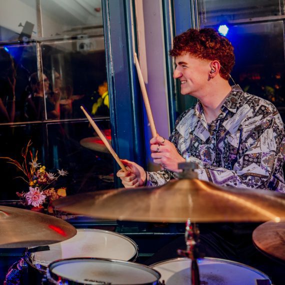 Drummer of Yorkshire wedding band, The Cat and and Mac Band, playing with passion behind a drum set for a wedding reception in Yorkshire.